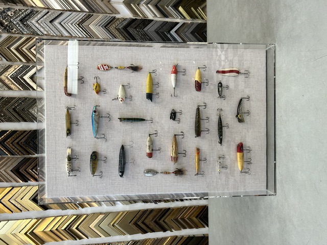Vintage fishing lures mounted in a linen shadowbox