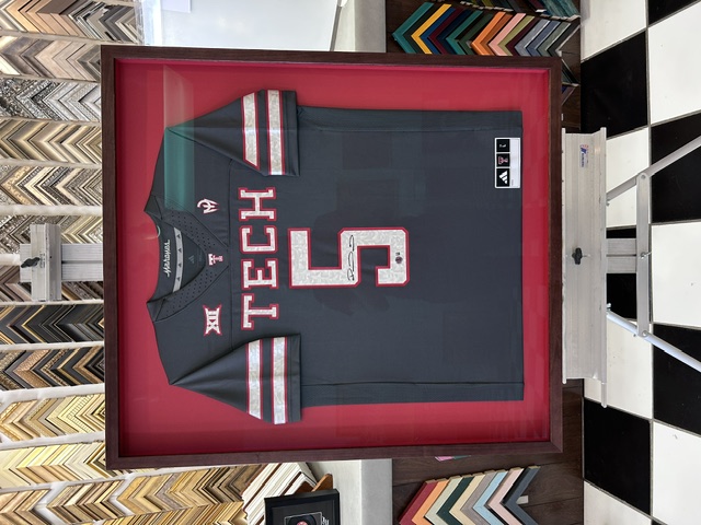 Signed Texas Tech football jersey in a shadowbox with a red mat